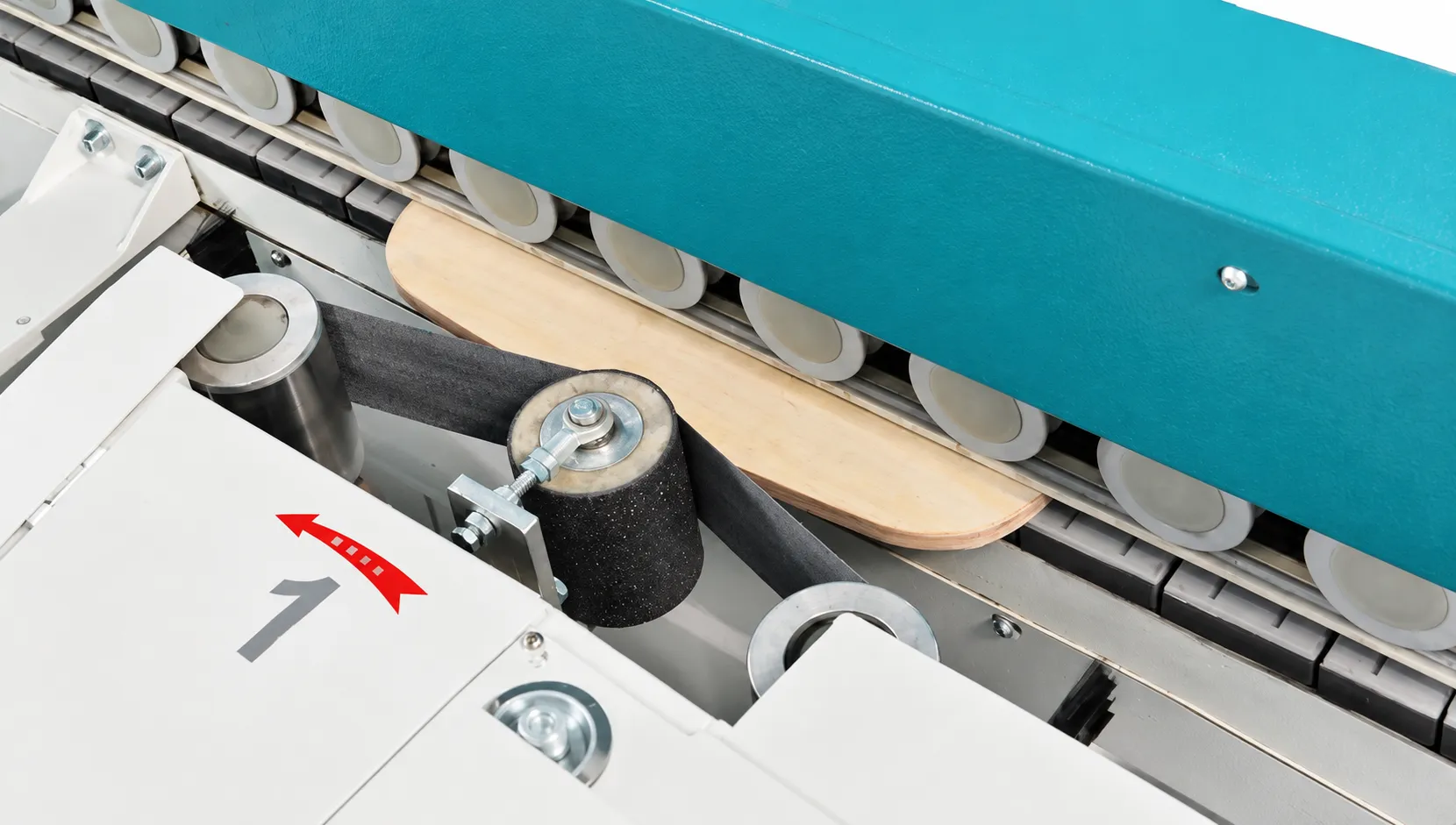 Adjustable belt sanding head contacting a shaped wood workpiece under hold-down rollers