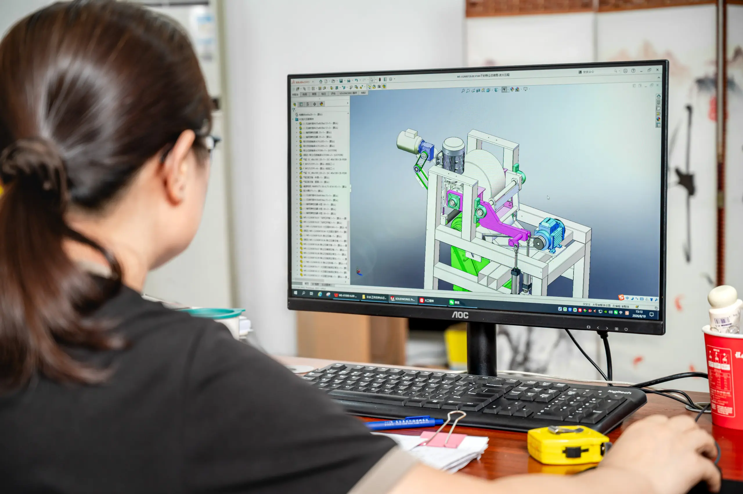 Engineer reviewing a custom sanding-machine assembly in CAD before manufacture